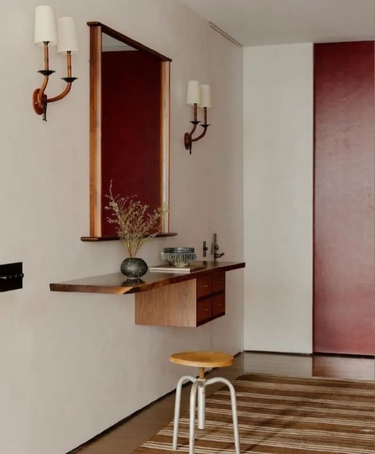 a bathroom with a vanity, stool and mirror