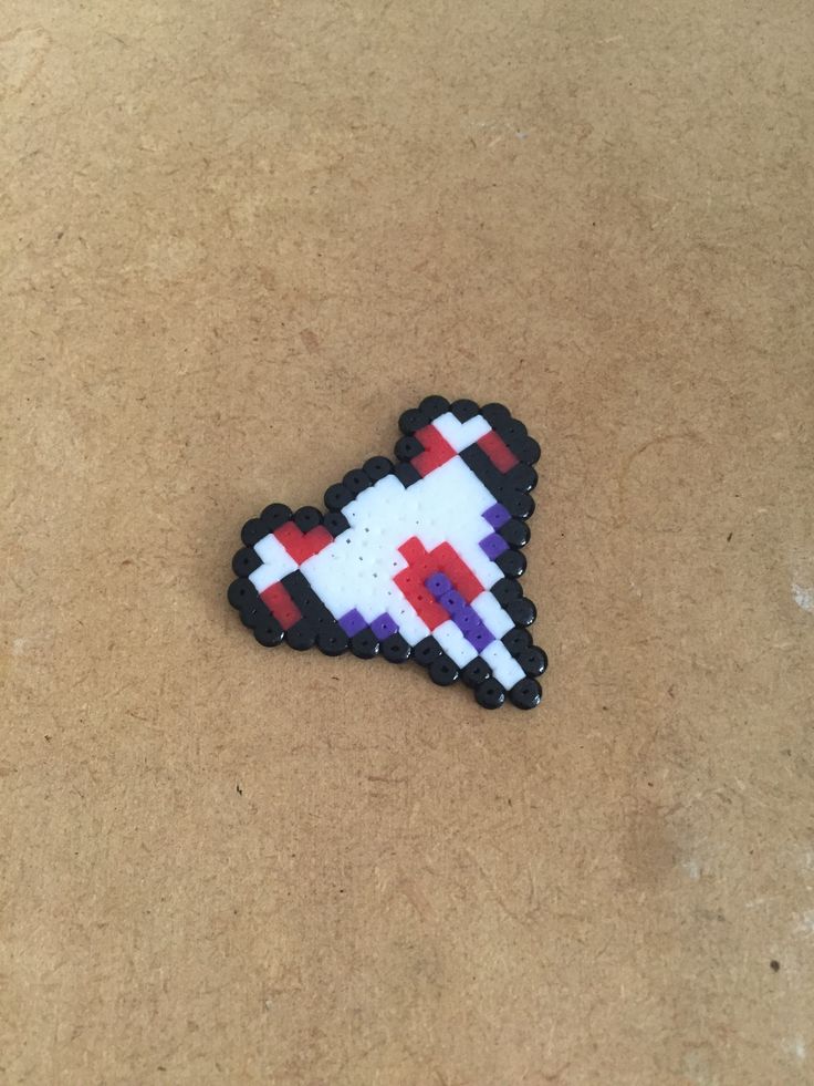 a pixel heart pin sitting on top of a table