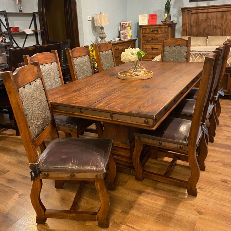 a dining room table and chairs with wooden floors