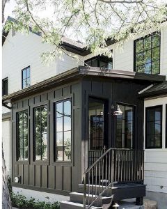 a small house with stairs leading up to the front door and windows on the second floor