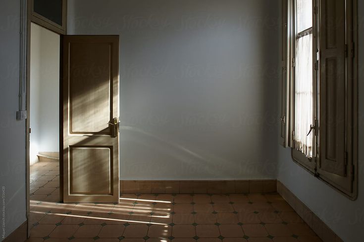 an open door in the corner of a room with tile flooring and white walls