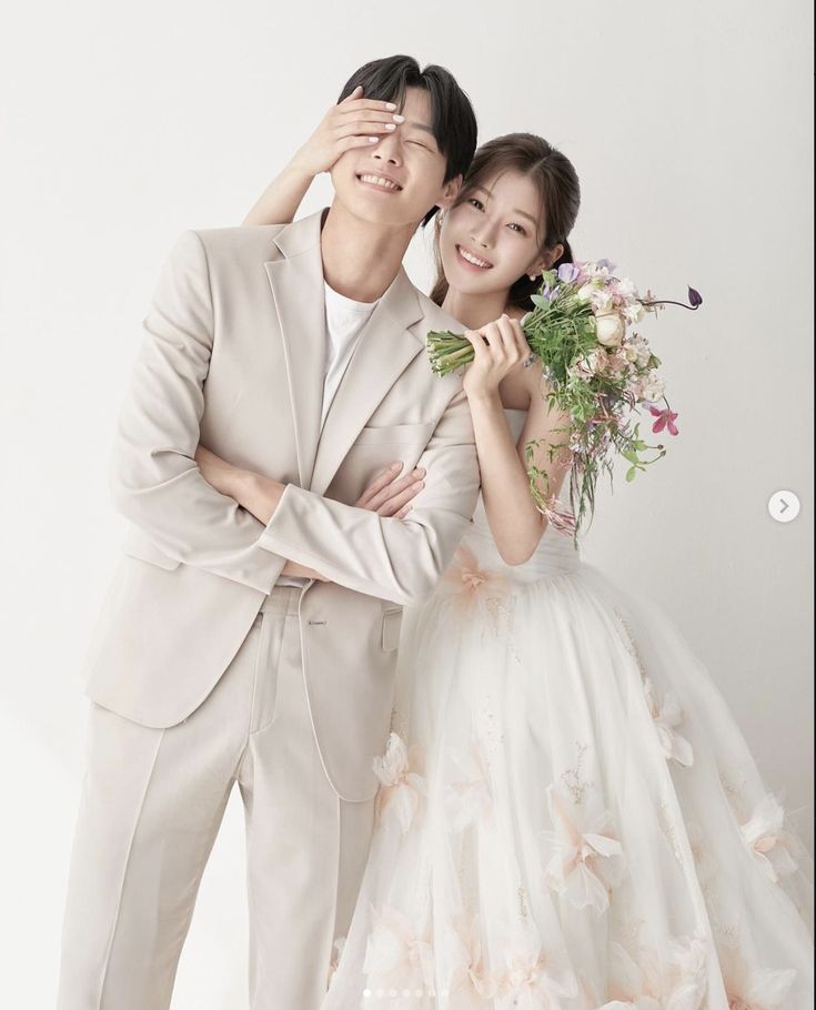 a man and woman posing for a photo with flowers in front of their eyes,