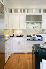 a kitchen with white cabinets and stainless steel appliances is pictured in this image, there are plates on the counter