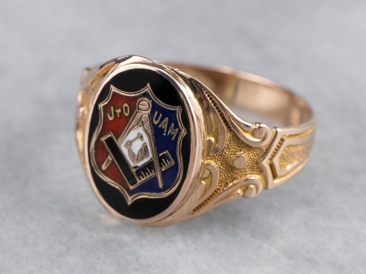 This antique fraternal ring represents the Junior Order of United American Mechanics! The enamel detailing is crisp and bold, and the scrolling designs on the ring's shoulders have a textured relief that feels luxurious. What a great ring! Metal: 10K Yellow and Rose Gold Materials: Black, Red, White, and Blue Enamel Top Measurements: 12 x 15 mm, Oval Ring Size: 11.75 Marks: "OB 10K" Stamped on the inside band Classic Enamel Hallmarked Rings, Classic Engraved Enamel Jewelry, Formal Engraved Enamel Signet Ring, Heirloom Black Enamel Signet Ring, Antique Enamel Rings For Collectors, Antique Enamel Rings As Collectibles, Heirloom Enamel Jewelry With Engraving, Heirloom Engraved Enamel Jewelry, Engraved Enamel Ring