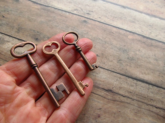 two antique keys are held in the palm of someone's hand