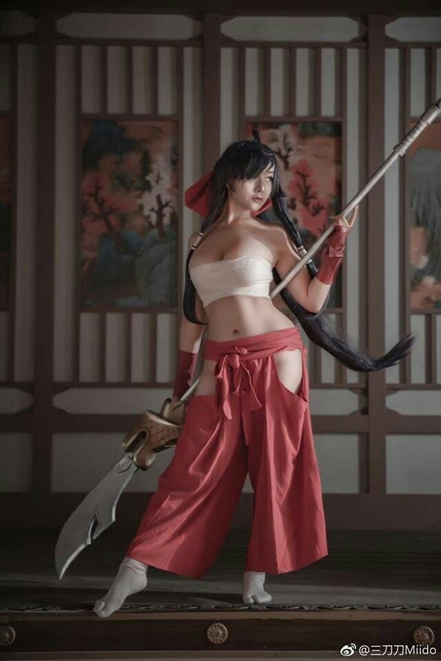 a woman with long black hair holding two swords in her hands and wearing red pants