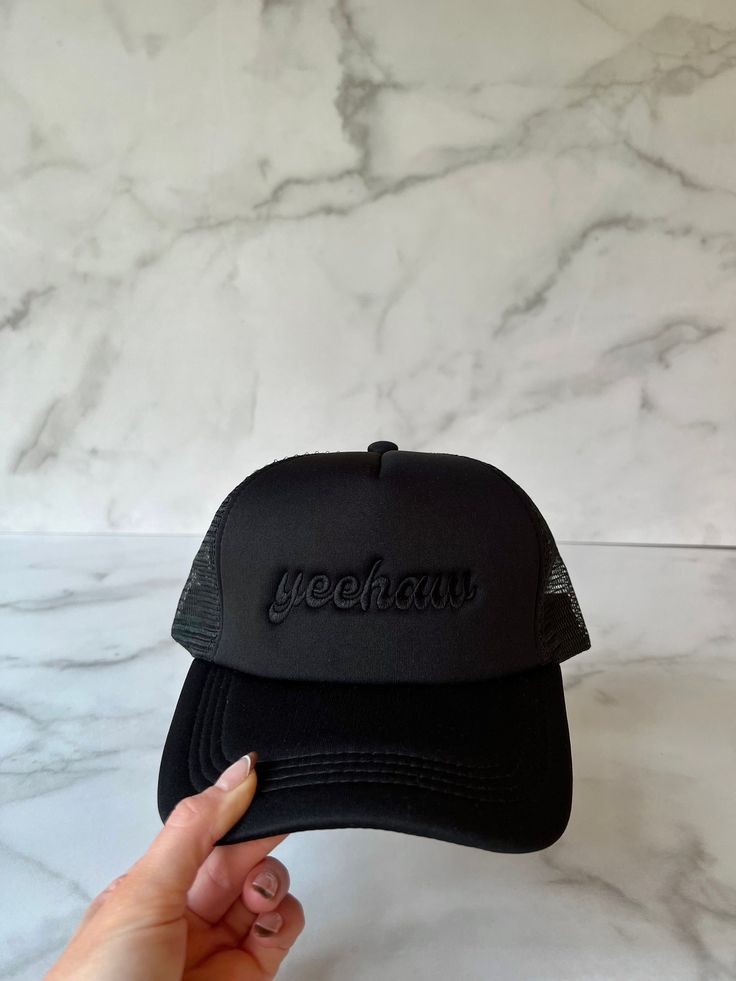 "Black foam trucker hat | Black hat with Black \"yeehaw\" embroidery." Affordable Black Sports Fan Trucker Hat, Black Trucker Hat With Letter Print And Curved Brim, Black 5-panel Hat With Letter Print, Black 5-panel Snapback Hat With Letter Print, Black 5-panel Trucker Hat With Letter Print, Bachelorette Hats, Trucker Hat Black, Black Trucker Hat, Black Writing