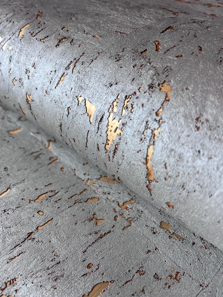 a close up view of the surface of a grey fabric with brown spots on it