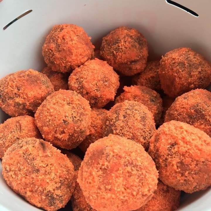 a white bowl filled with meatballs sitting on top of a table