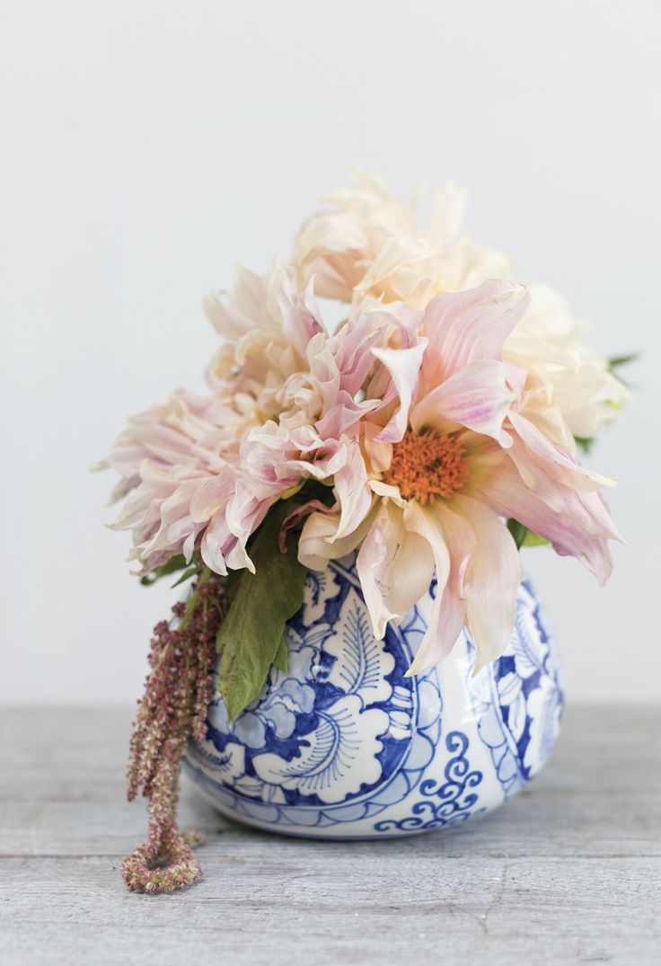 a blue and white vase with flowers in it