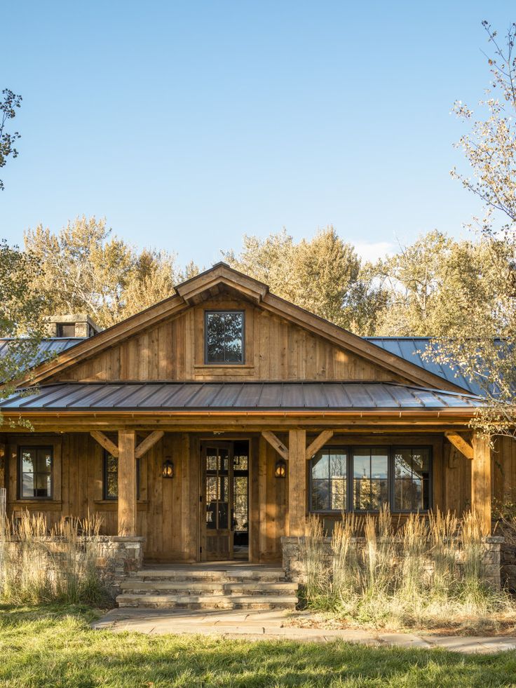 a large wooden house sitting on top of a lush green field