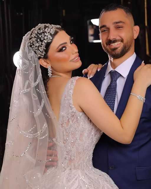 the bride and groom are posing for a photo in their wedding day attire, with one arm around the other's shoulder