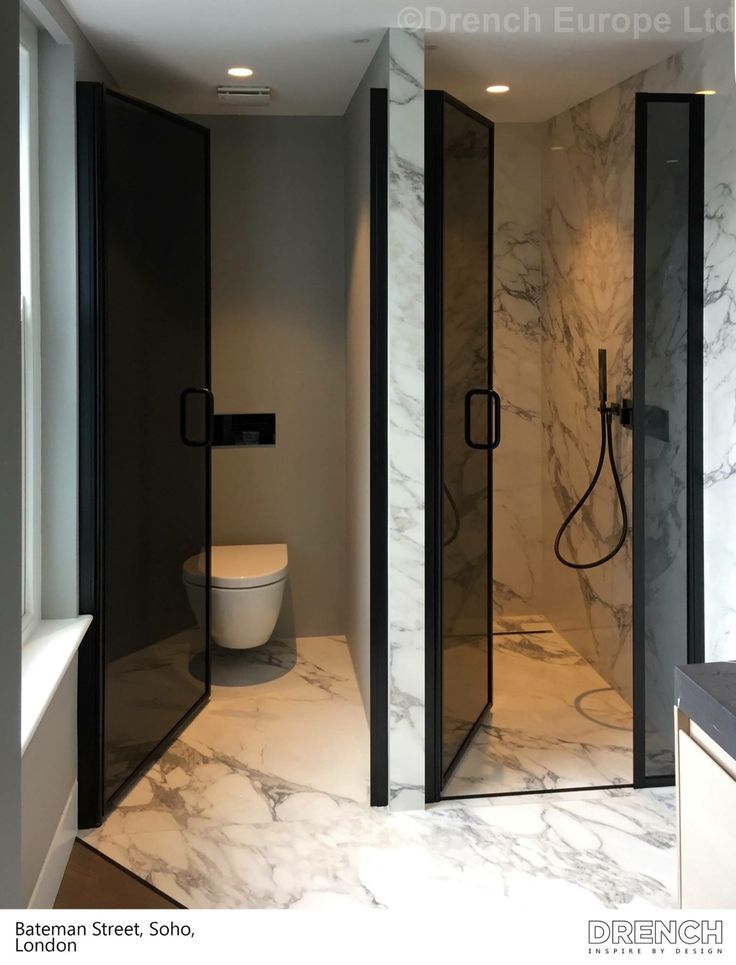 a bathroom with marble walls and flooring next to a toilet in a shower stall