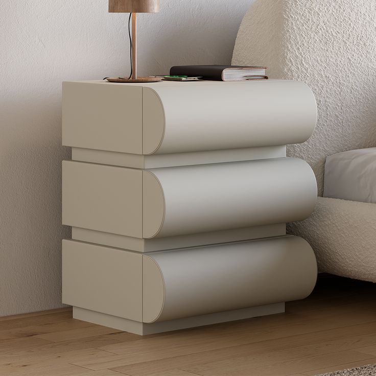 a lamp sitting on top of a table next to a white chair in a room