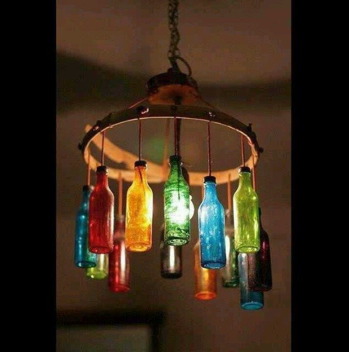 a chandelier made out of glass bottles hanging from a light fixture in a room