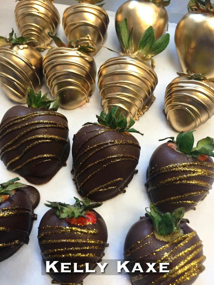 chocolate covered strawberries are lined up on a white surface with gold foiled decorations