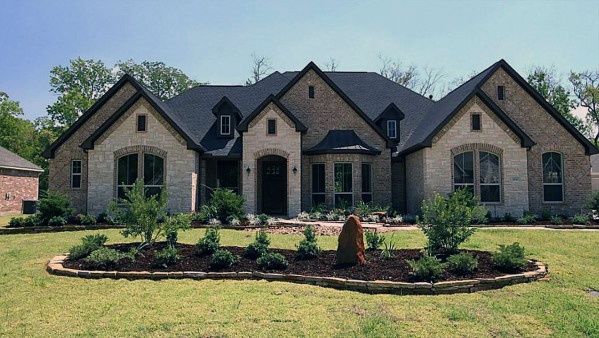 a house with landscaping in front of it and an advertise for the home