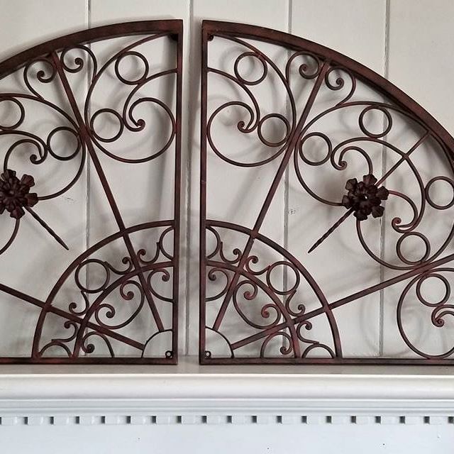 two decorative iron doors on the side of a wall