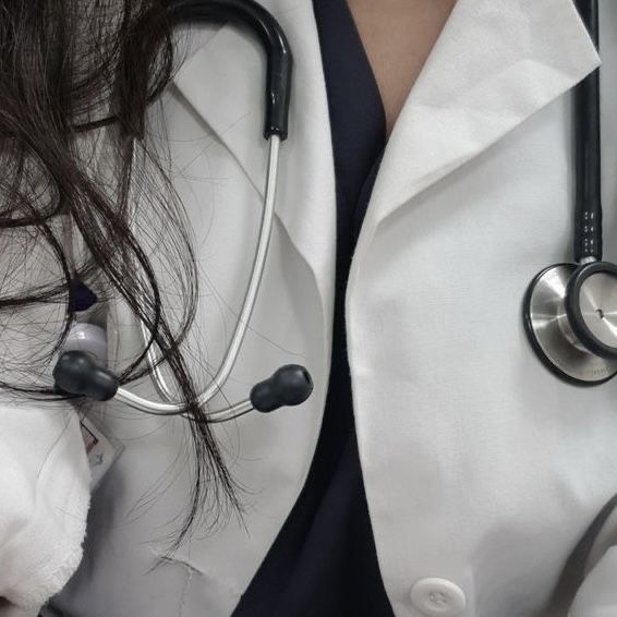 a close up of a person wearing a white coat and stethoscopes