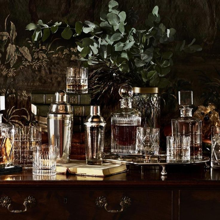 an assortment of liquor bottles and glasses on a table