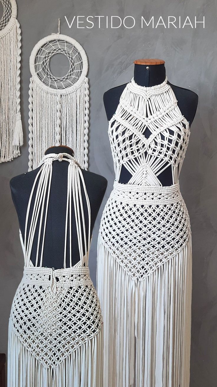 two mannequins with white crochet dresses on display next to each other