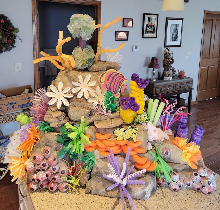 there is a large display made out of rocks and paper mache flowers on the table