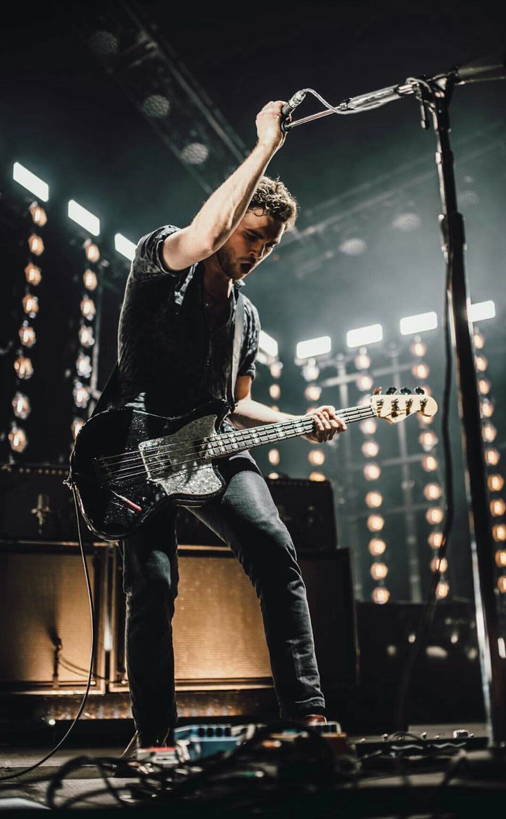 a man playing guitar on stage at a concert