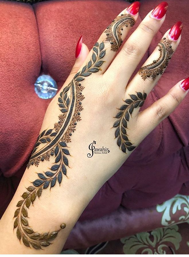 a woman's hand with henna tattoos on it