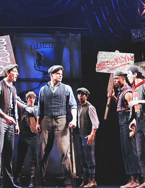 a group of men standing next to each other on a stage with signs in front of them