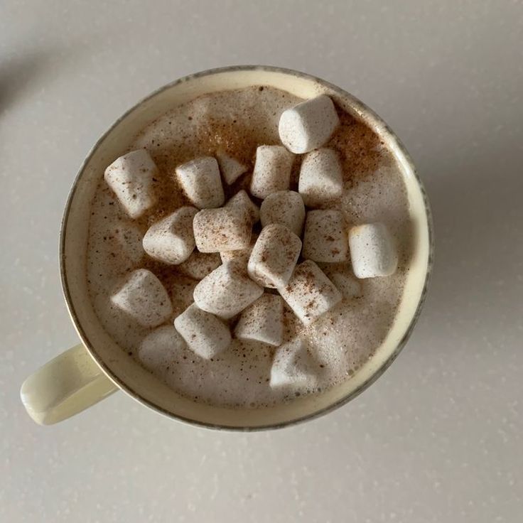 a cup filled with hot chocolate and marshmallows