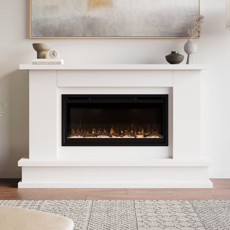 an electric fireplace in a living room with a painting on the wall and a rug