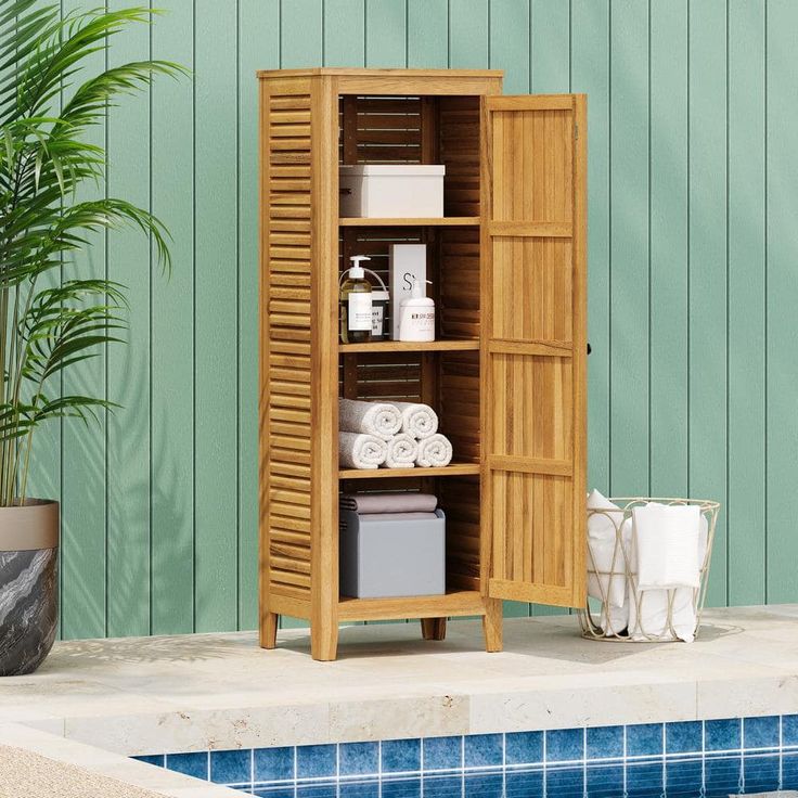 a wooden cabinet next to a swimming pool with towels and toiletries on it's shelf