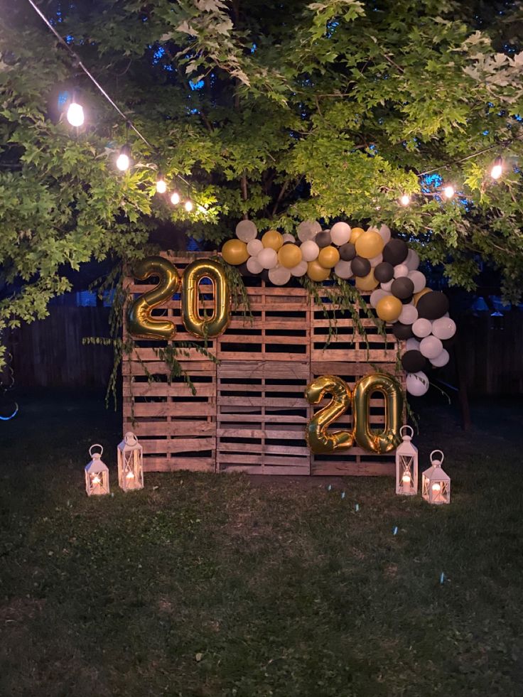 an outdoor birthday party with balloons and lights