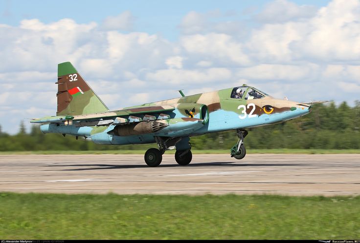 a fighter jet sitting on top of an airport tarmac with trees in the background