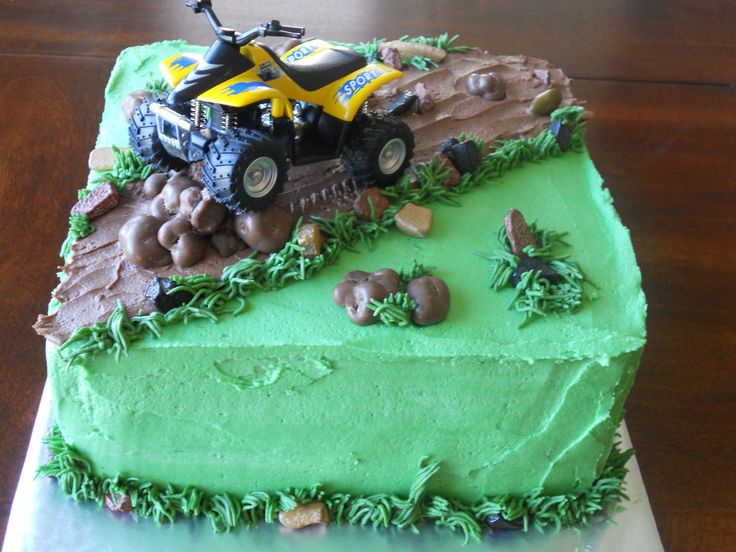 a birthday cake with green frosting and an atv on top