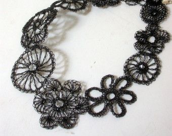 a black crocheted bracelet with flowers on it