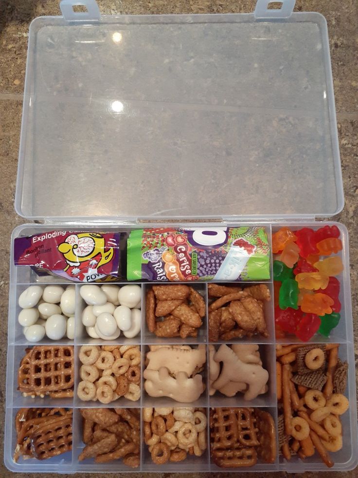 a plastic container filled with lots of different types of snacks and treats in it's lid