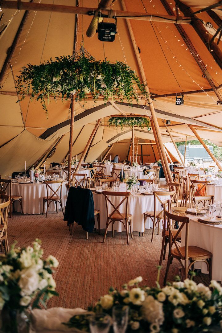 the inside of a large tent with tables and chairs set up for an outdoor function