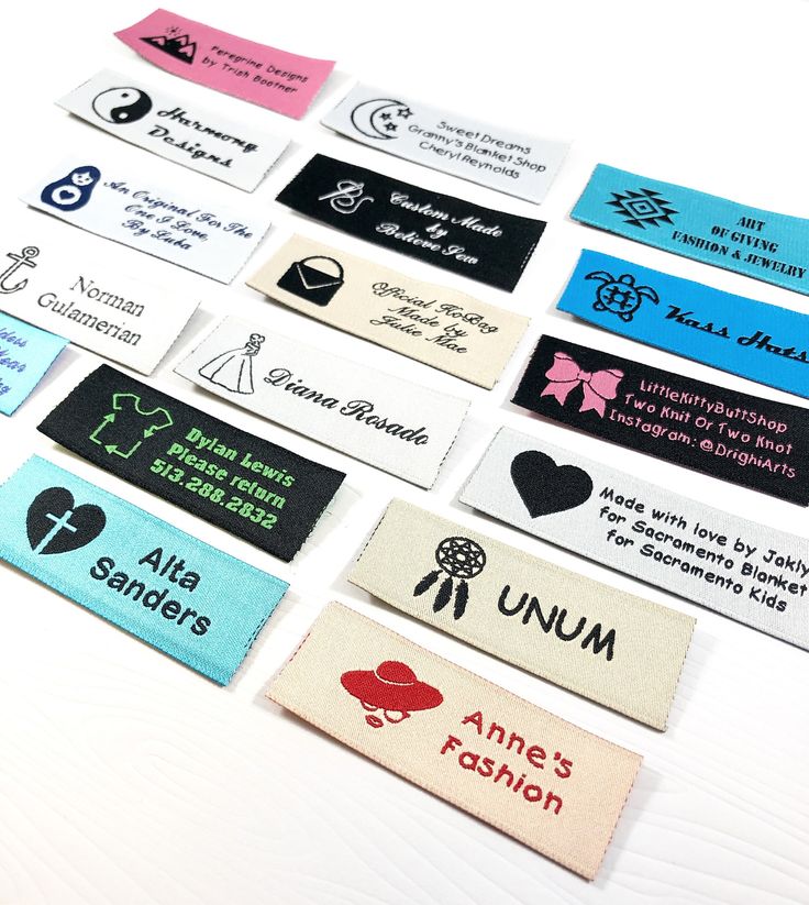 several different types of name tags on a white table top with black and pink lettering