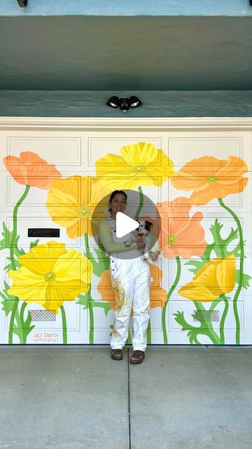 a man standing in front of a garage door with yellow flowers painted on the side