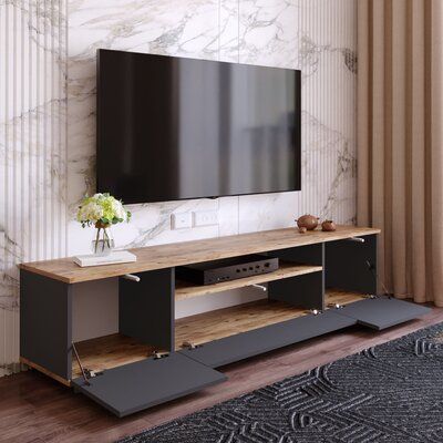 an entertainment center with a flat screen tv mounted on it's side, in front of a marble wall