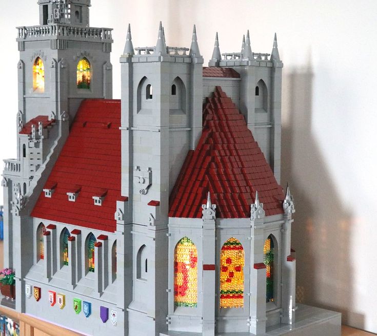 a lego castle is shown on top of a wooden table in front of a white wall