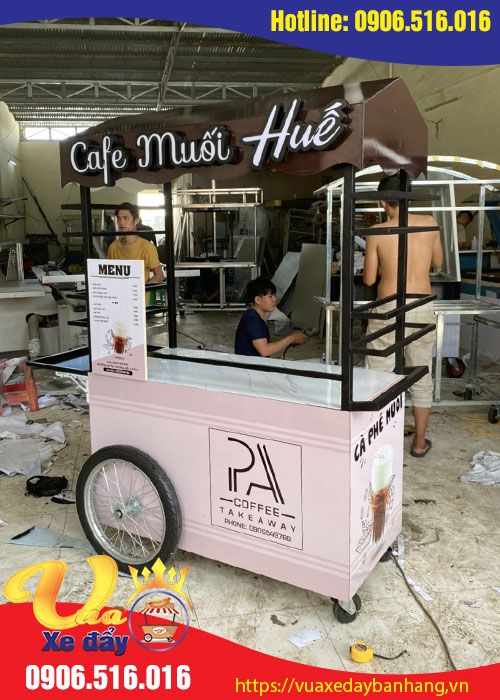 an ice cream cart with people working behind it