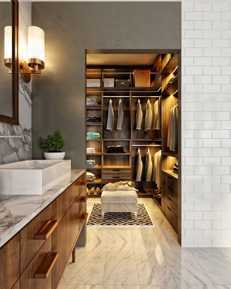 an image of a walk in closet with clothes on the shelves and towels on the shelf