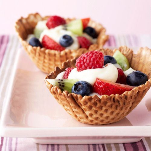 two waffle cups filled with fruit and yogurt