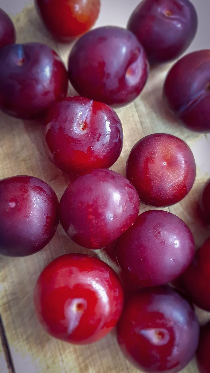 some plums are sitting on a cutting board