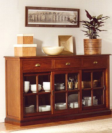 a wooden cabinet with glass doors and shelves filled with plates, cups and bowls on top