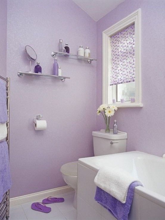 a bathroom with purple walls and white fixtures