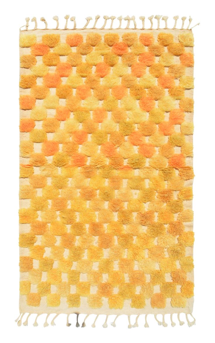 an orange and yellow rug with fringes on it's sides, in the shape of squares