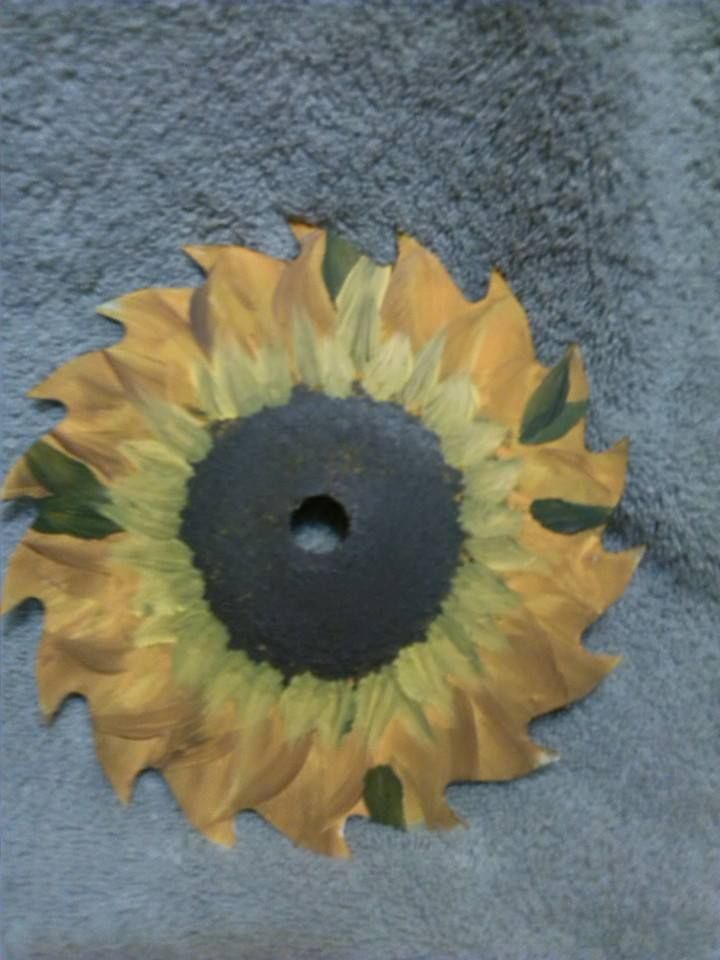 a sunflower is painted on the side of a gray wall with green leaves around it